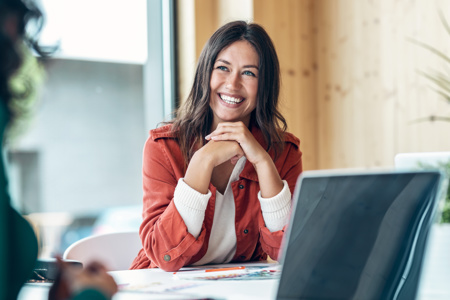 A woman smiling at camera sitting at desk